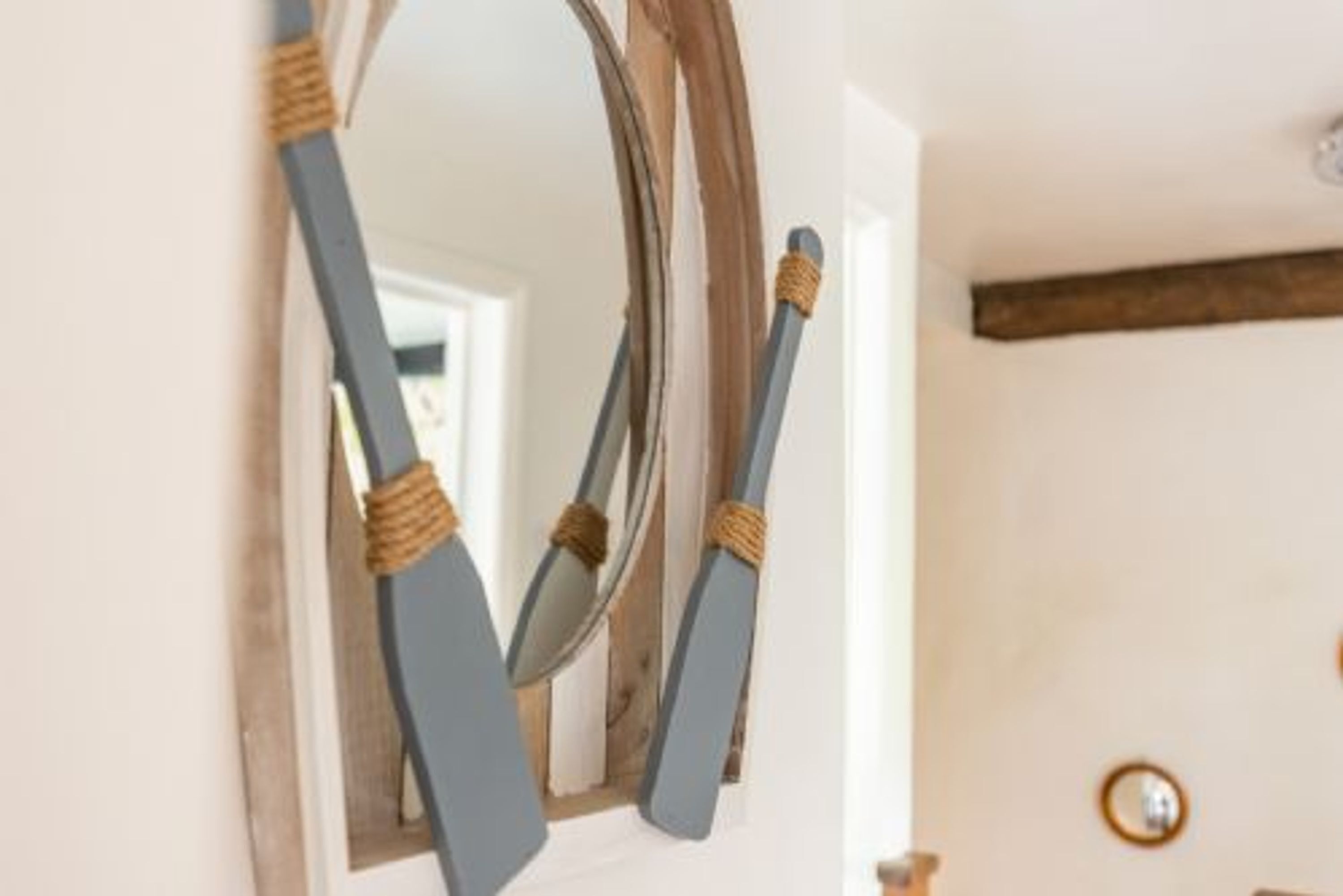 Een spiegel met houten lijst en touwbevestigingen.