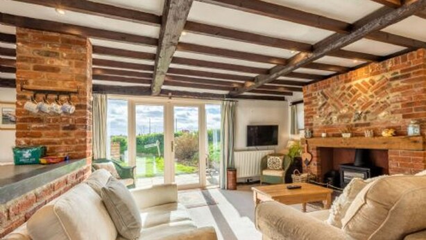 A cozy living room with a fireplace, a sofa, and a television.