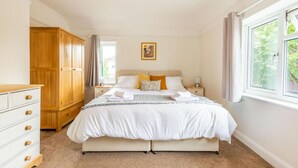 Une chambre à coucher avec un lit, une armoire, une table de chevet et une fenêtre.