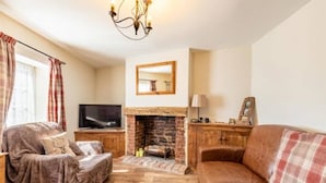 A living room with a fireplace, a television, and a sofa. - Host Stay West Street Cottage (Cromer)