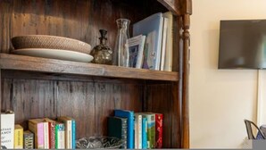 Une bibliothèque en bois, avec des livres et des objets décoratifs.