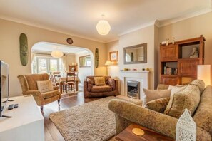 A cozy living room with a fireplace, comfortable seating, and a television. - Host Stay Applegarth House (Norwich)