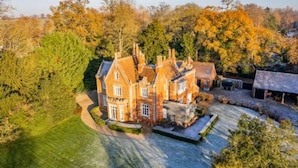 A large, historic house with a symmetrical facade, multiple chimneys, and a well-maintained lawn. - Host Stay Bressingham Lodge (Diss)