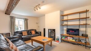 A living room with a fireplace, a television, and a bookshelf. - Host Stay 2 Ruscon Cottage (King's Lynn)