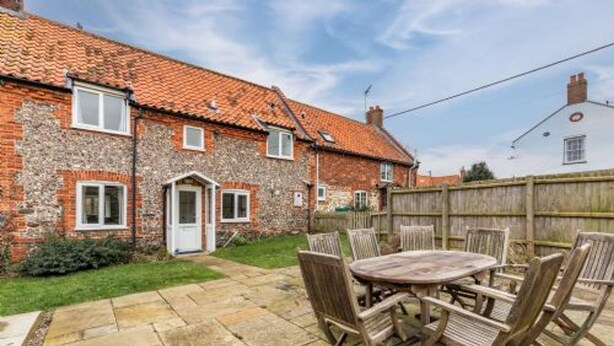 A brick house with a tiled roof, a front door, and a small front yard with a wooden fence. - Host Stay 2 Ruscon Cottage (King's Lynn)