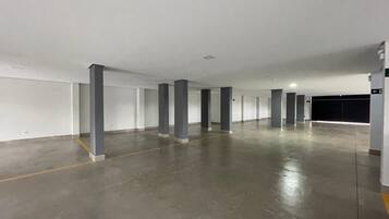 A large, empty parking garage with concrete floors and white walls.