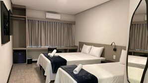 A hotel room with two beds, a wardrobe, a mirror, and an air conditioning unit. - Escarpas Styles Hotel (Capitólio)