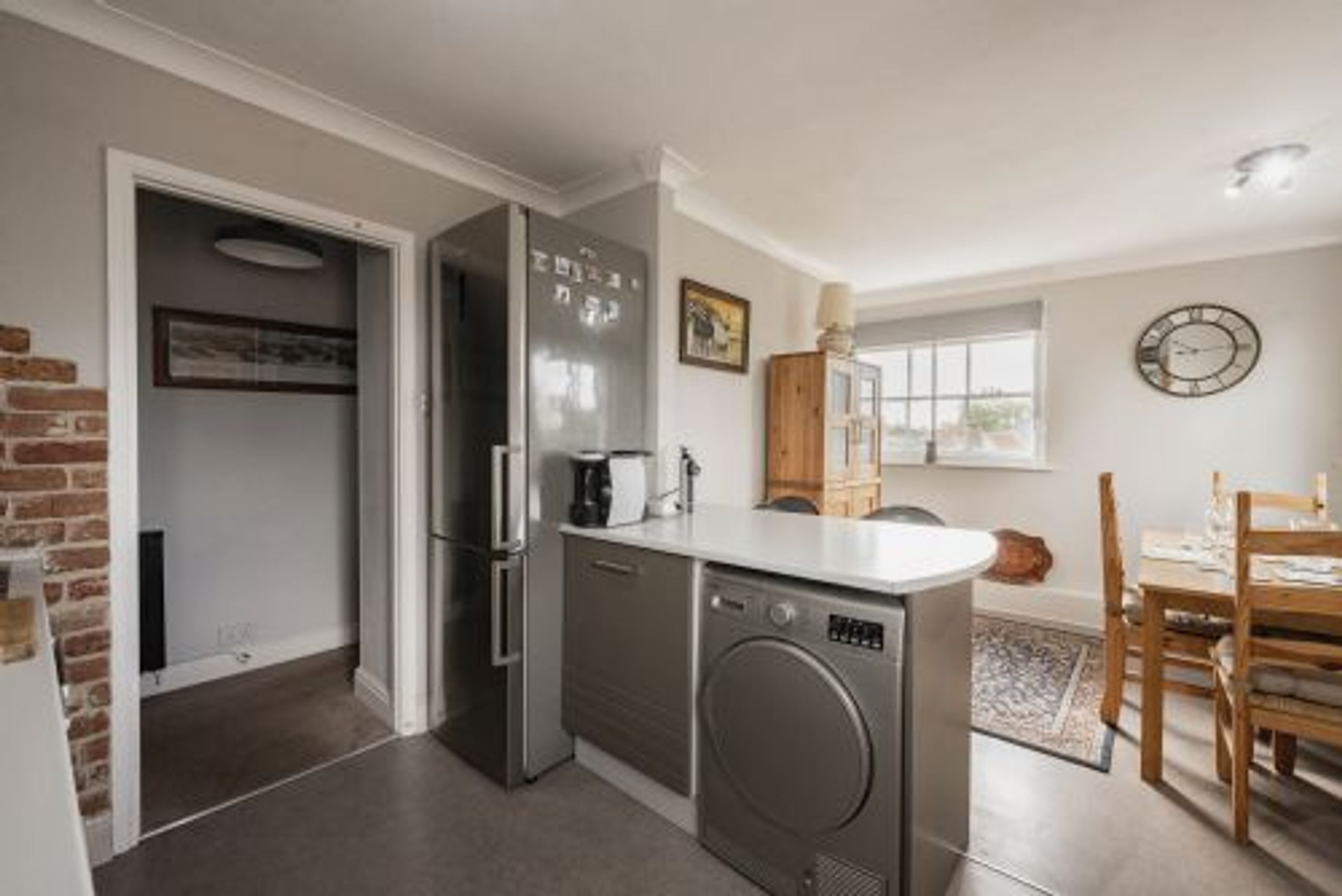 Una cocina compacta equipada con lavavajillas, refrigerador y pileta.