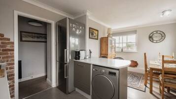 Una cocina compacta equipada con lavavajillas, refrigerador y pileta.