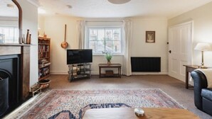 A living room with a fireplace, television, and a large rug. - Host Stay Manor View (Fakenham)