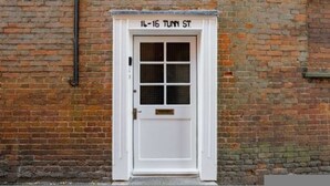 A white door with a grid pattern and a brass handle, labeled "14-16 TUNN ST." - Host Stay Manor View (Fakenham)