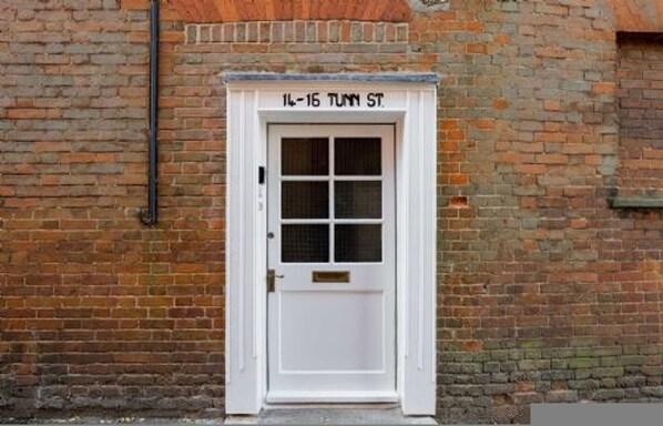 A white door with a grid pattern and a brass handle, labeled "14-16 TUNN ST." - Host Stay Manor View (Fakenham)