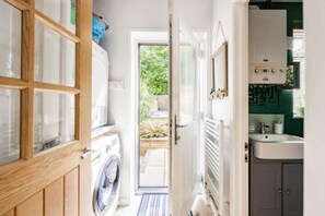 Une buanderie équipée d’un lave-linge, d’un sèche-linge et d’un radiateur.