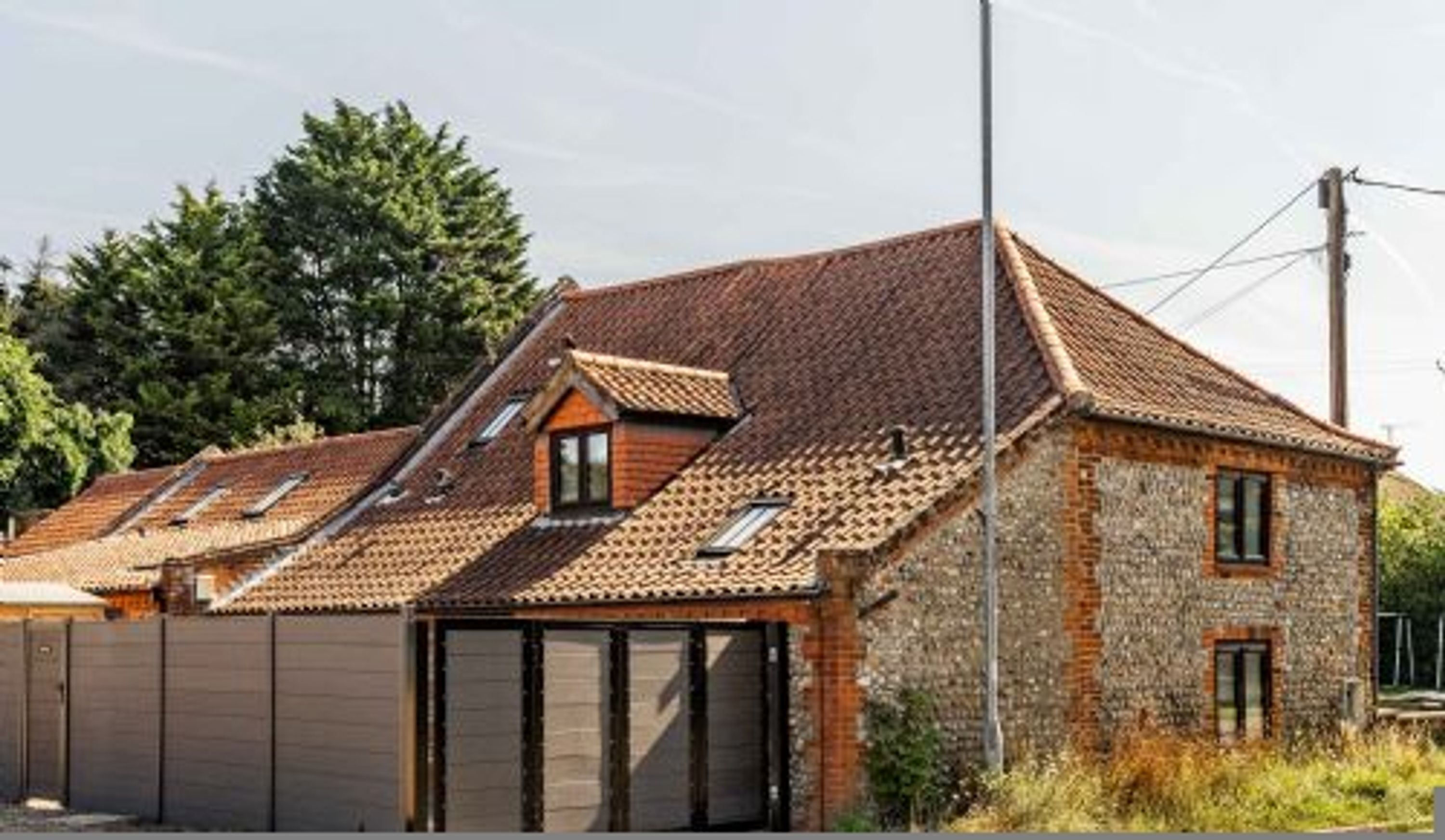 A two-story house with a sloped roof, a garage, and a stone exterior.