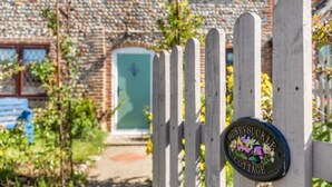 A wooden gate with a sign reading "Honeybush Cottage." - Host Stay Honeysuckle Cottage (Cromer)