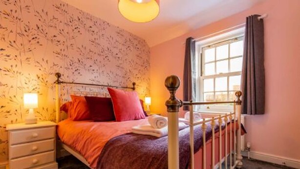 A bedroom with a bed, nightstand, and window. - Host Stay The Courtyard (King's Lynn)