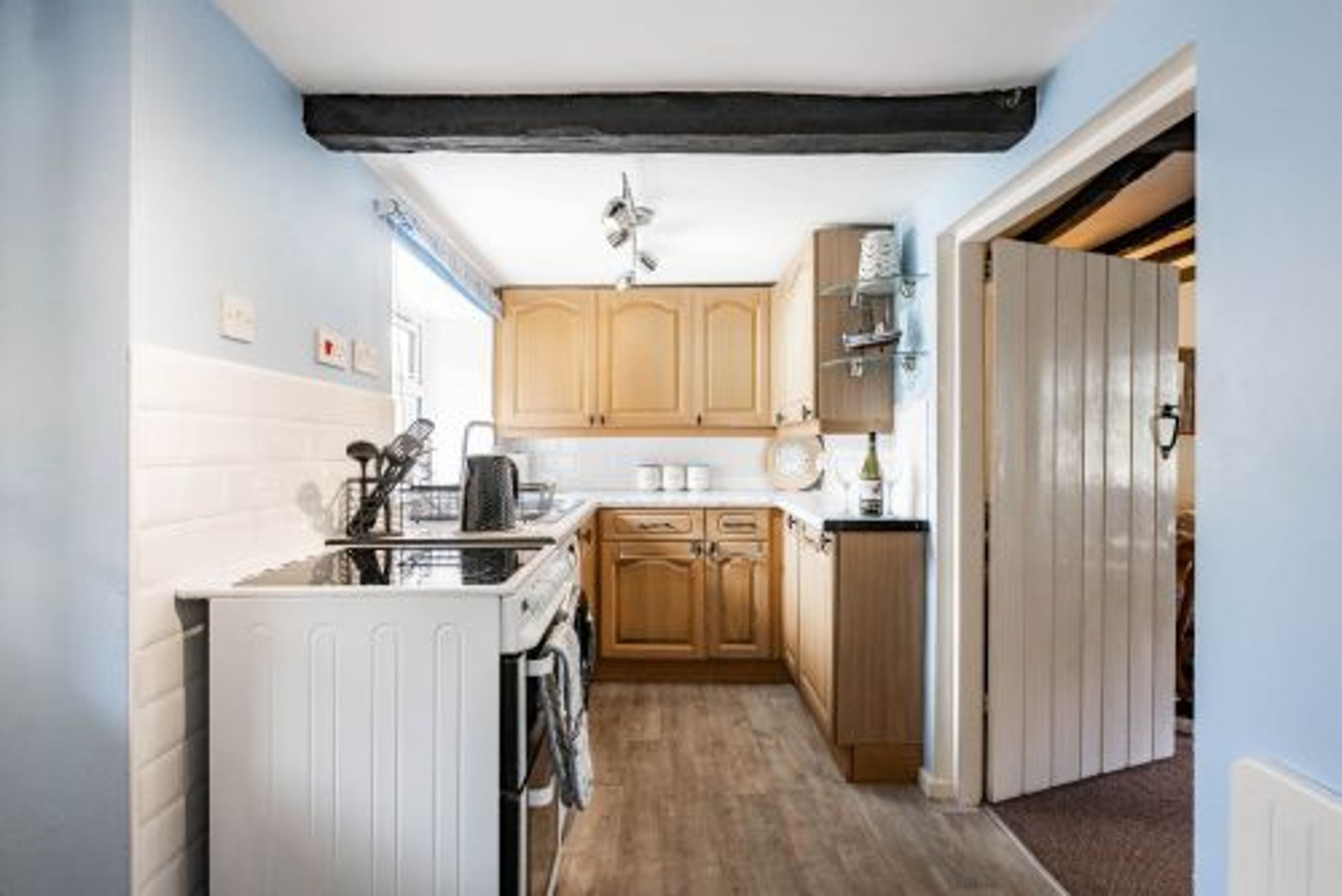 A compact kitchen with wooden cabinets, a built-in oven, and a radiator.