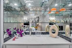 A modern interior with glass display shelves and a white countertop. - Hollywood Glam Hideaway (Palm Springs)