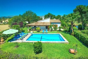 A house with a swimming pool, surrounded by greenery and a clear blue sky. - Finca Gerania, a quiet vacation home with a garden and pool, 3 km from the beach (IB)
