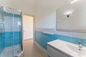 Appartement | Badkamer | Een douche, een haardroger, handdoeken