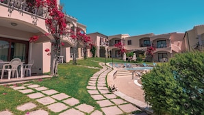 A resort with multiple balconies, a swimming pool, and a well-maintained lawn. - I Giardini di Badus (Badesi)