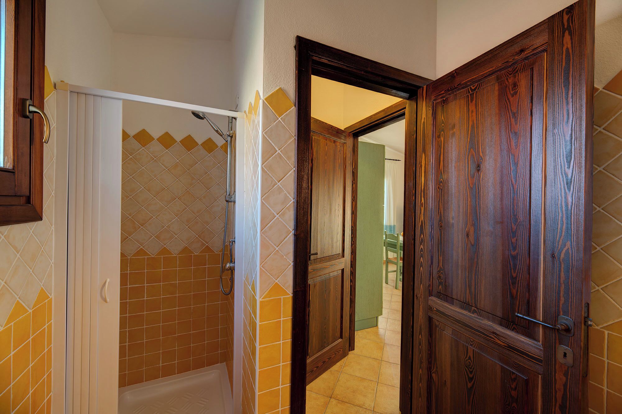Un baño con ducha, inodoro y puerta de madera.