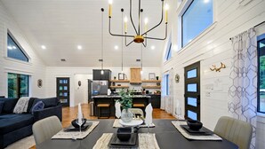 A modern interior with a dining area, kitchen, and living space. - Top % Secluded 1.25ac: Spa Bath, Tub & Pull-Thru (Broken Bow)