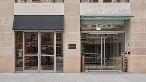A building facade with a 'MINT HOUSE' sign, large glass doors, and a fire hydrant. - Mint House Washington DC Downtown by Kasa (Washington)