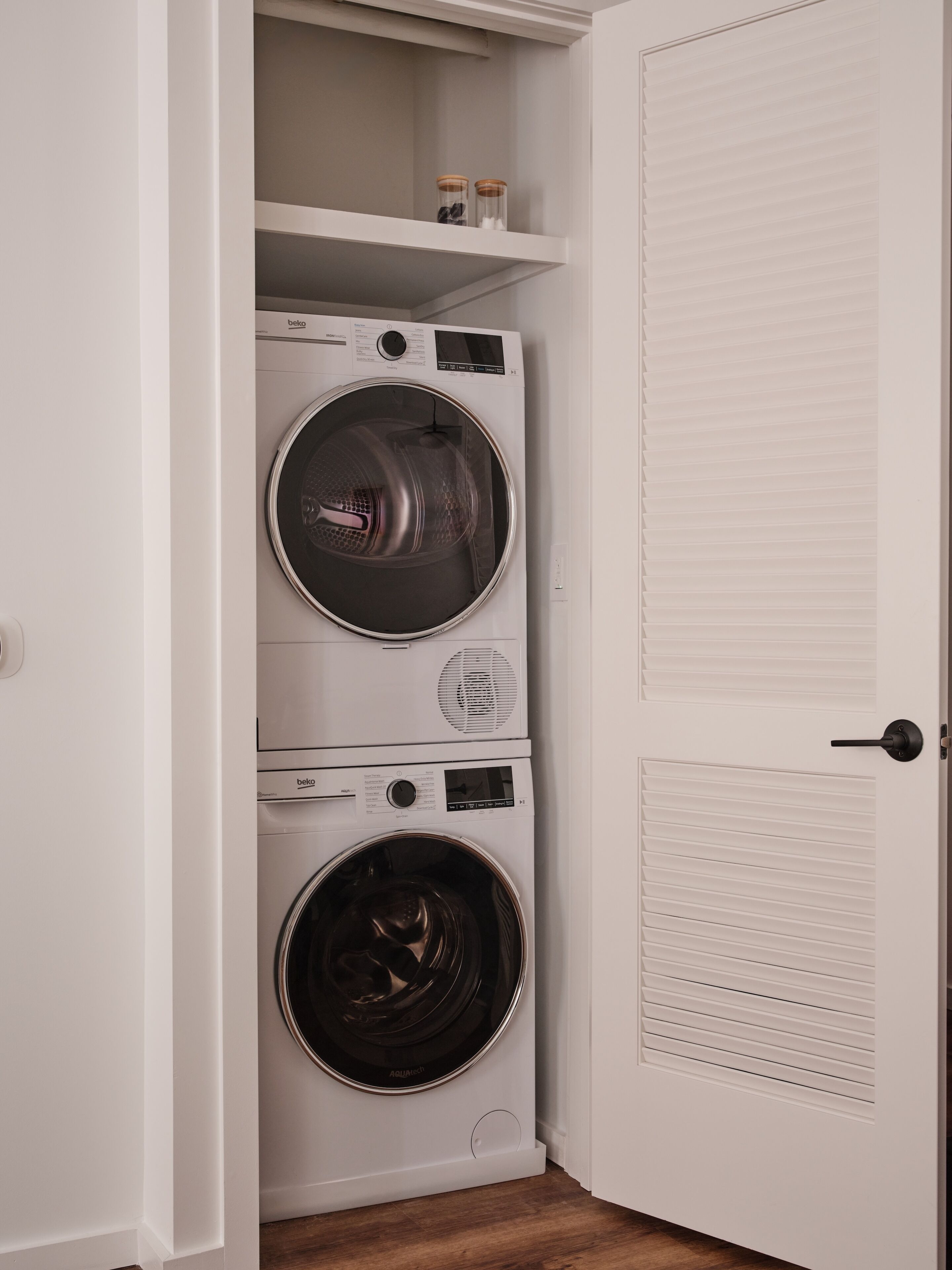 A laundry room with two front-loading washing machines and a dryer.