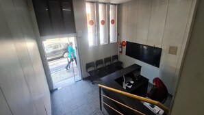 A hotel lobby with a reception desk, seating area, and a large window with a view of the street. - Hotel Rodoviária Belo Horizonte (Belo Horizonte)