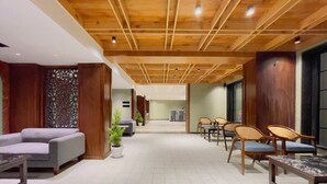 A spacious lobby with a wooden ceiling, seating areas, and a reception desk. - Paradise Premium (Srinagar)