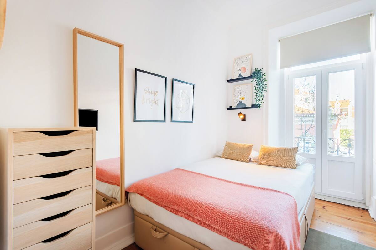 Ein Schlafzimmer mit Bett, Schminktisch, Spiegel und Fenster mit Blick.