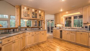 Una cocina amplia con armarios de madera, una isla grande y vistas al exterior.