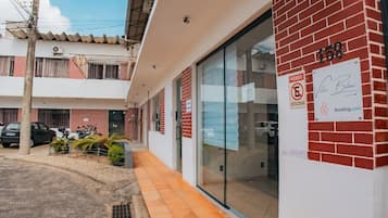 Un edificio de fachada de ladrillo rojo, entrada de cristal y un letrero que indica prohibido estacionar.