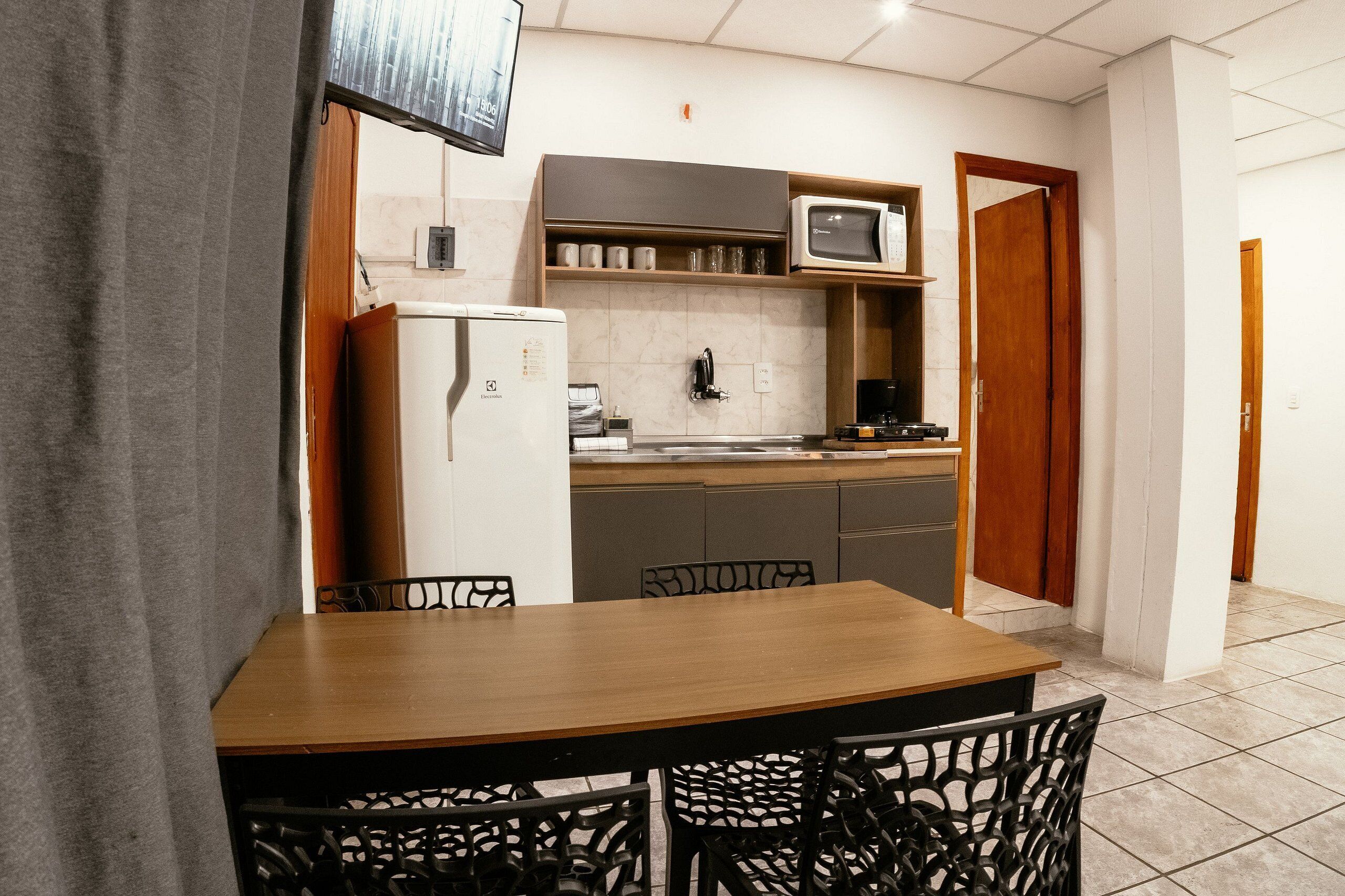 A compact kitchen with a refrigerator, microwave, and coffee maker.