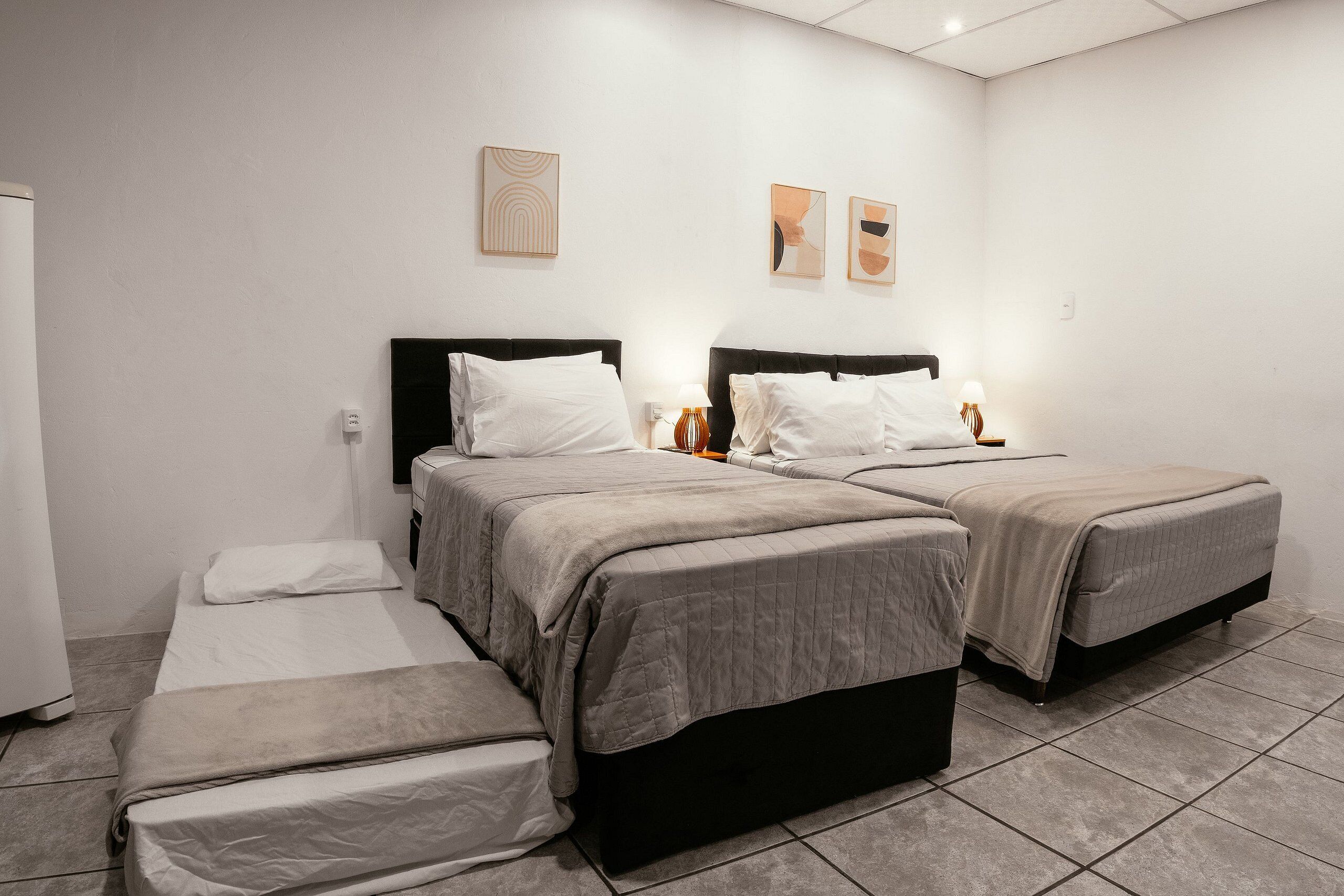 Una habitación de hotel con dos camas, una mesita y una silla.