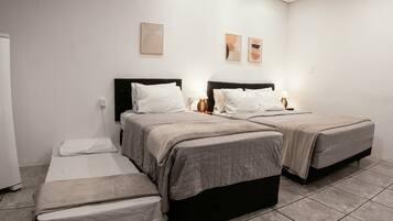 Una habitación de hotel con dos camas, una mesita y una silla.