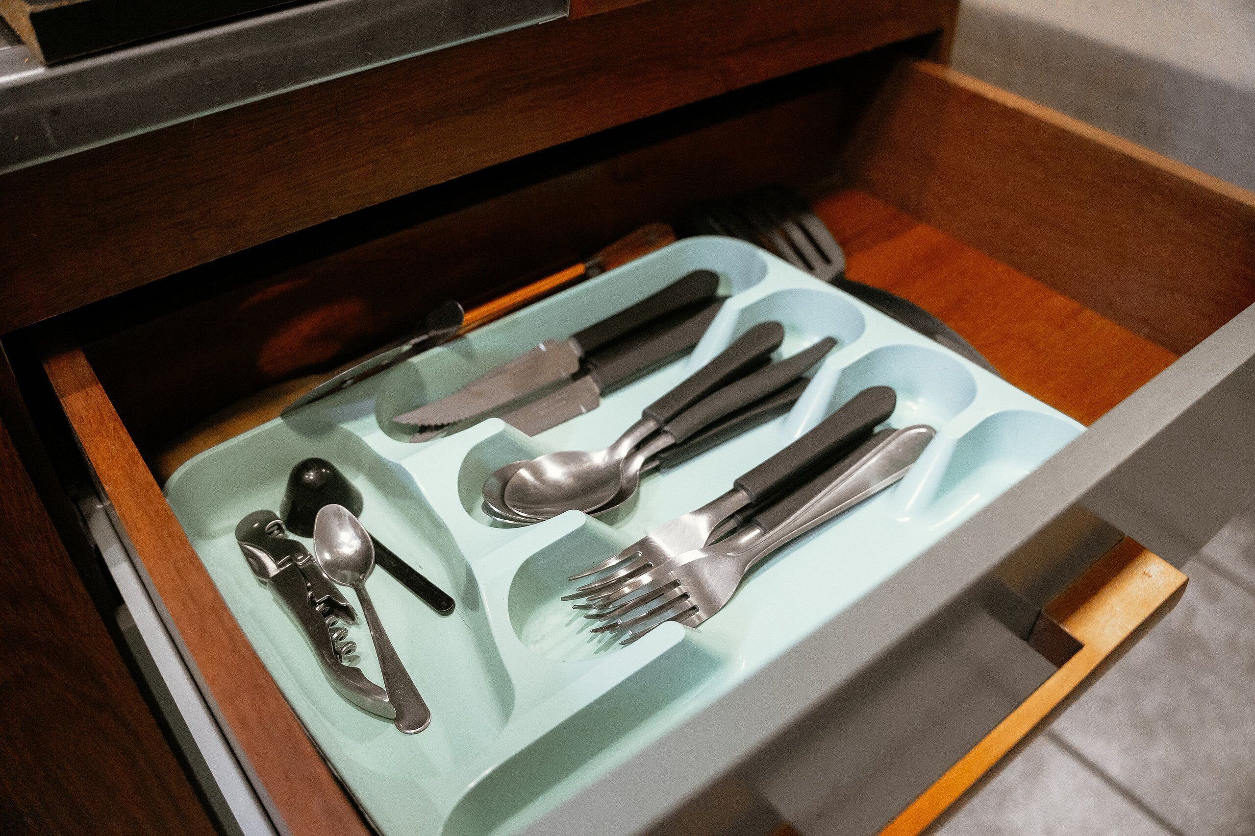 A drawer with utensils neatly arranged inside.