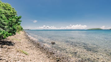 Na praia, espreguiçadeiras, toalhas de praia