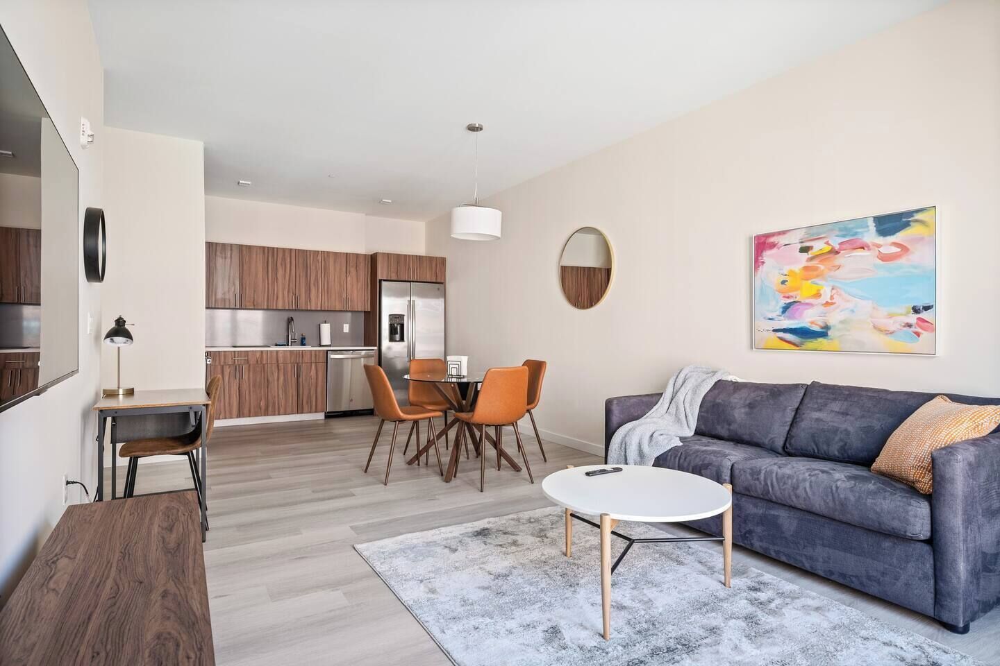 A modern apartment with a dining area, kitchen, and living room.