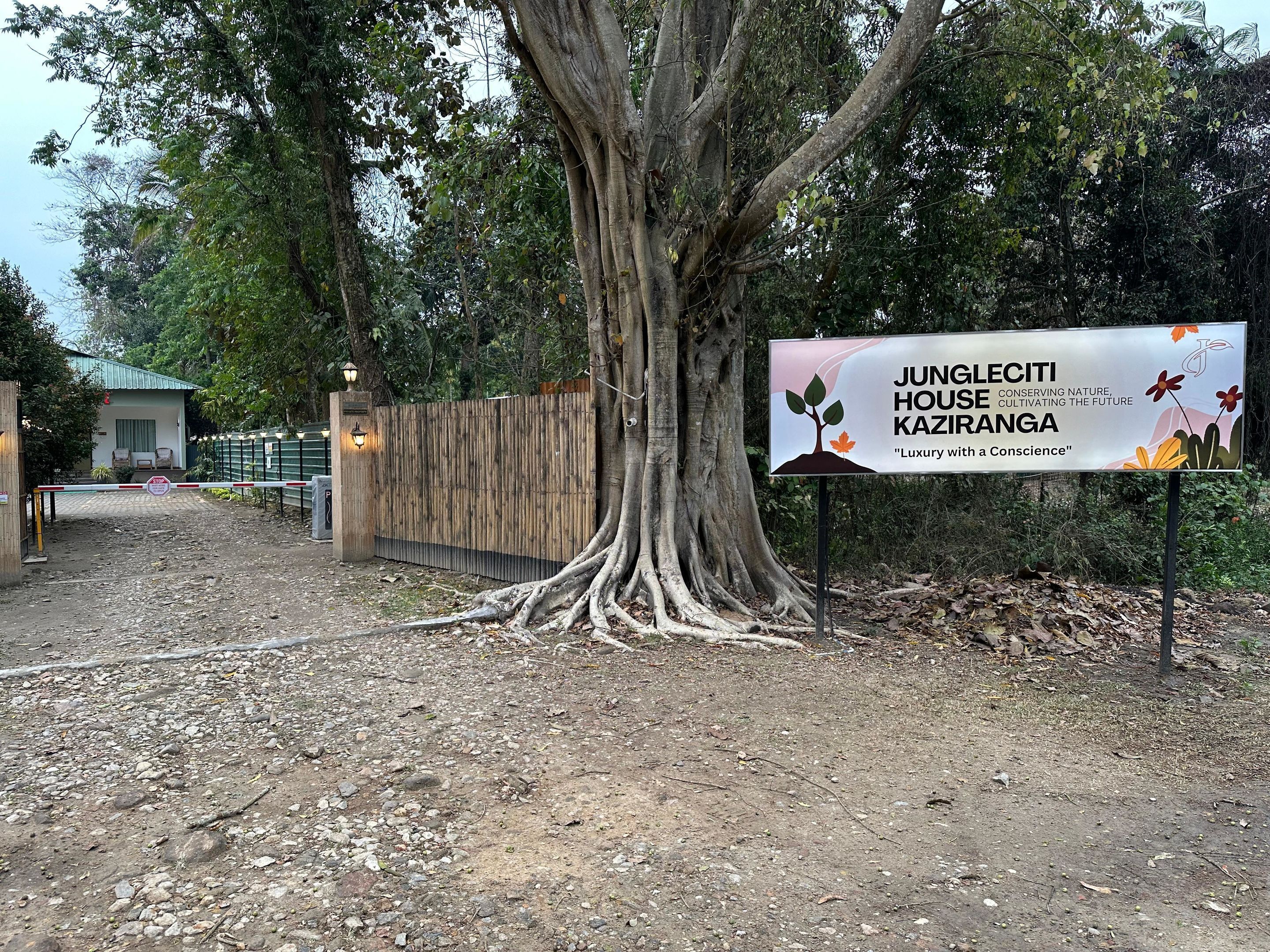 A sign for Jungleciti House Kaziranga, highlighting its focus on nature conservation and luxury.