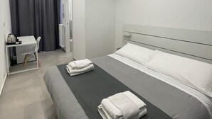 A modern hotel room with a bed, a desk, and a chair. - Porta Nuova Suite 57  (Turin)