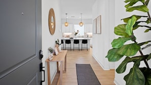 A modern kitchen with white cabinets, a wooden dining table, and pendant lighting. - Living the DREAM!  Golf and Sunset VIEWS! Brand NEW Home!  Gallery, Indian Palms (Indio)