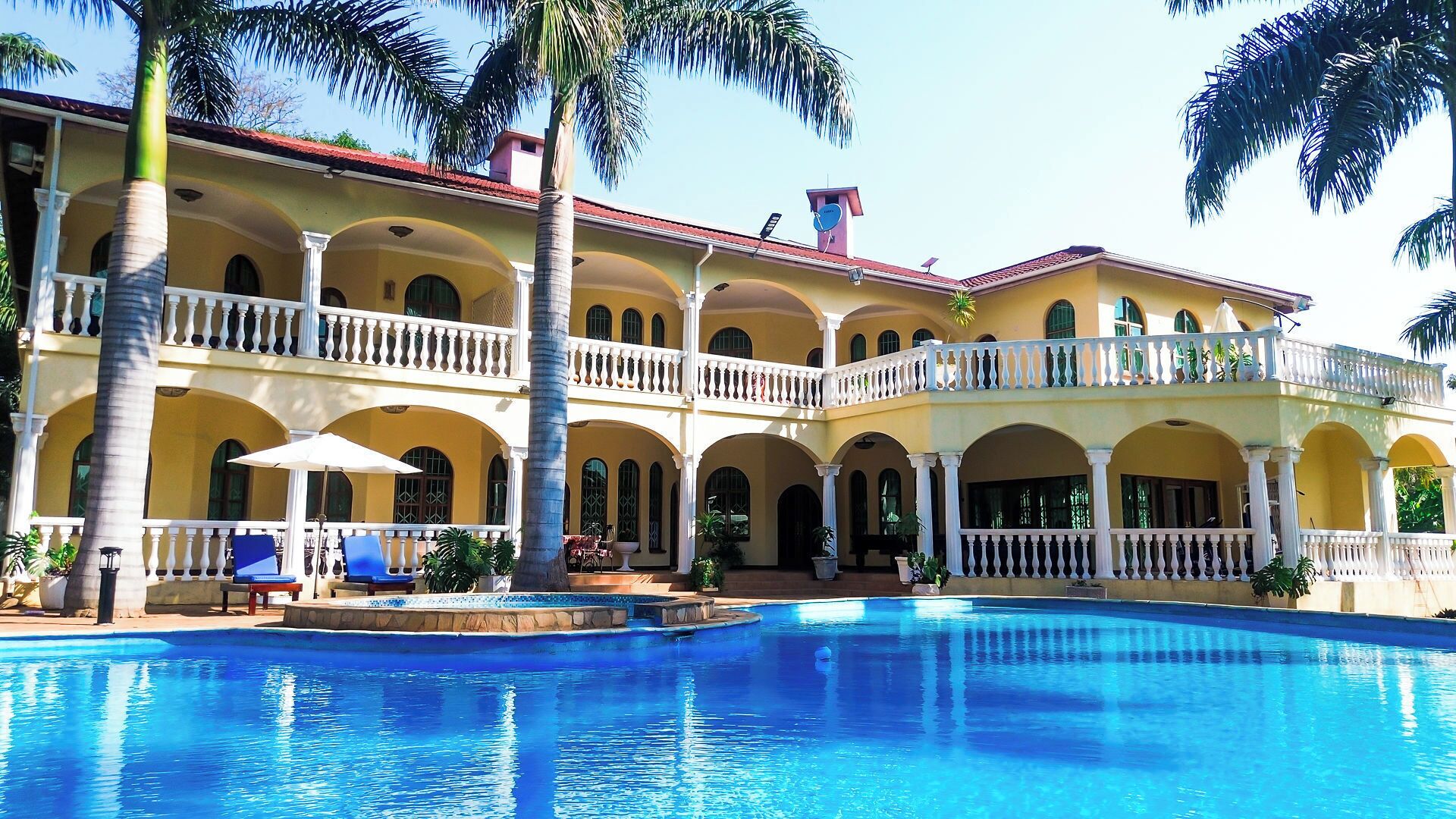A large, multi-story building with a swimming pool in the foreground.