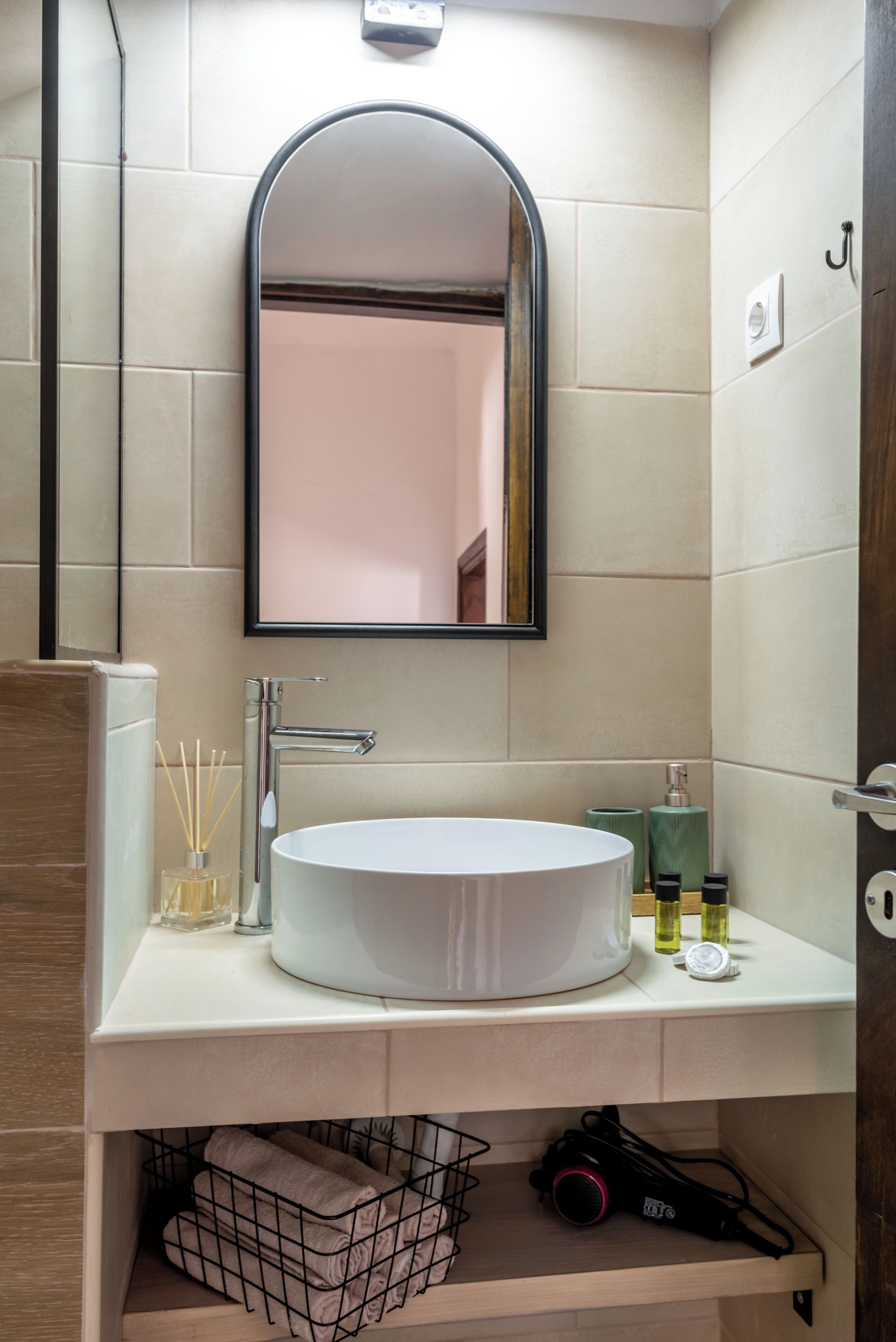 A bathroom with a white sink, a mirror, and a towel rack.