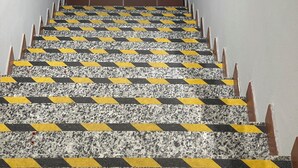 A staircase with a patterned floor, a handrail, and a door at the top. - Central Suite 57 (Turin)