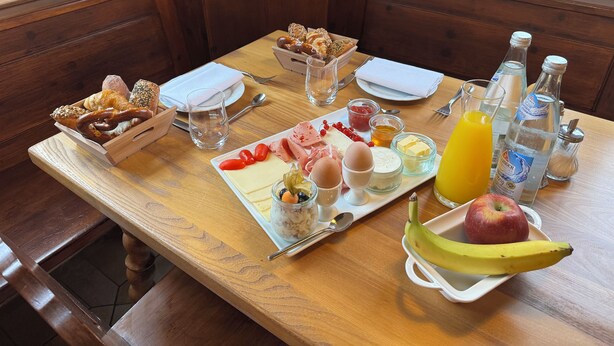 A breakfast table with various food items, including bread, eggs, cheese, and fruits, along with drinks and condiments. - Hotel Gasthof zur Post Benediktbeuern (Benediktbeuern)