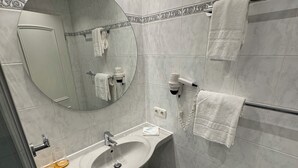 A modern bathroom with a sink, mirror, towel rack, and a trash bin. - Hotel Gasthof zur Post Benediktbeuern (Benediktbeuern)