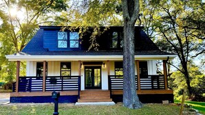 A two-story house with a porch, a mailbox, and a large tree in front. - Epic Retreat at Mystic Falls-5 bd 3.5 BA-1 Mile from the Square & Clocktower (Covington)