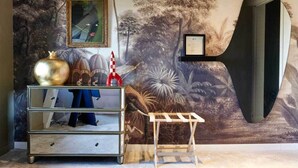 A room with a mural of trees and a large abstract sculpture.